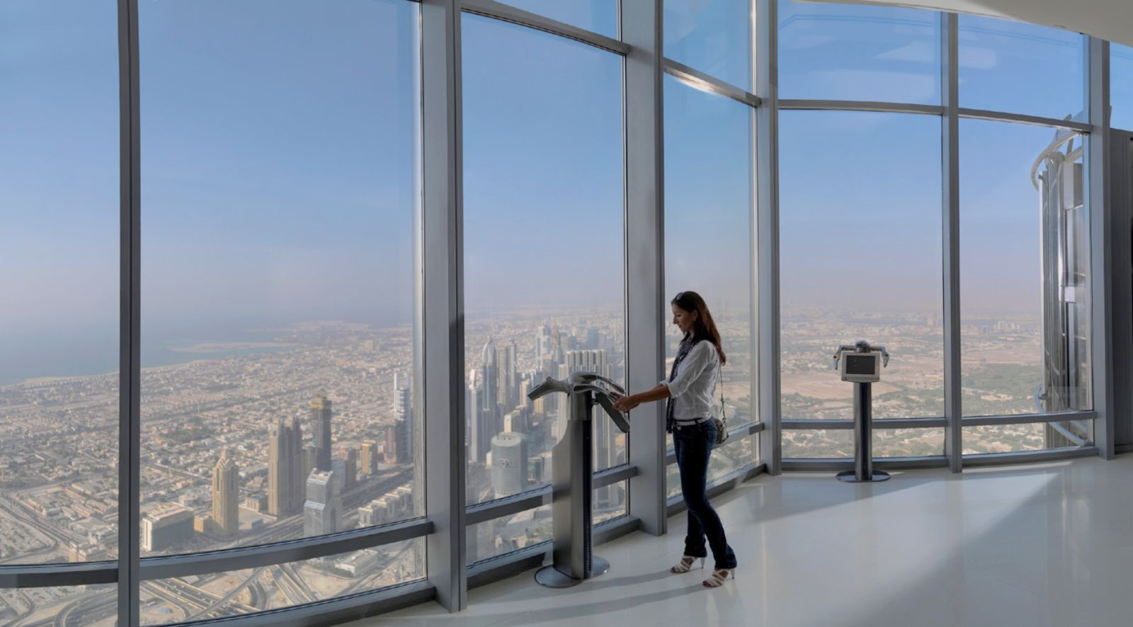 Guests dressed for evening enjoying the night view from Burj Khalifa At The Top